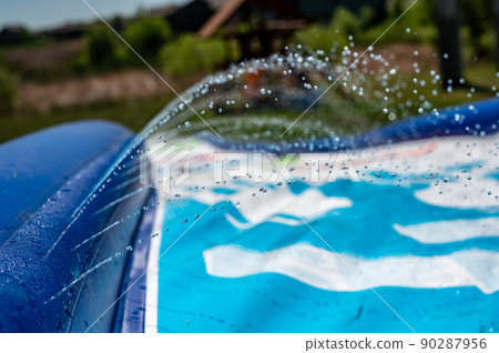Selective focus on jets of droplets shooting out across a water slide 90287956