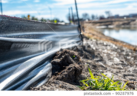 silt fence at a construction site with exposed dirt piled against the fabric 90287976