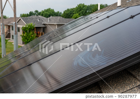 Selective focus on solar panels installed on a residential asphalt shingle roof 90287977