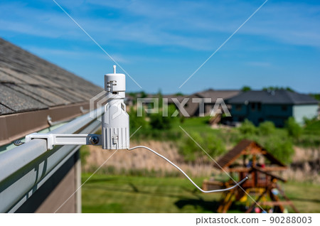 Wireless sprinkler rain sensor used to conserve water. Device is installed on a residential roof gutter Wireless sprinkler rain sensor used to conserve water. Device is installed on a residential roof gutter 90288003