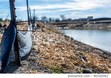 silt fence at a construction site with straw covered dirt and retention pond in background silt fence at a construction site with straw covered dirt and retention pond in background 90288062