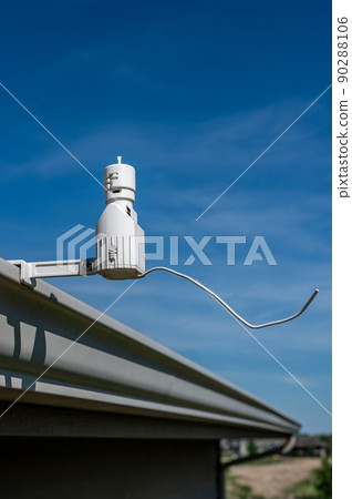 Wireless sprinkler rain sensor used to conserve water. Device is installed on a residential roof gutter 90288106
