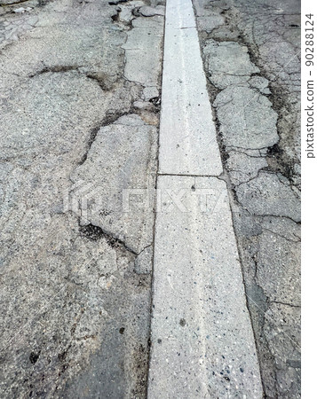 Pot hole and cracks in a road caused by heavy industrial loads Pot hole and cracks in a road caused by heavy industrial loads 90288124