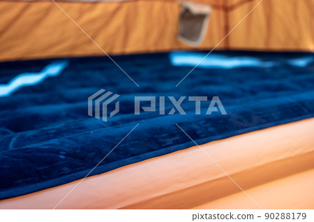 Selective focus of an inflatable air mattress on the floor of a tent being filled up. Selective focus of an inflatable air mattress on the floor of a tent being filled up. 90288179