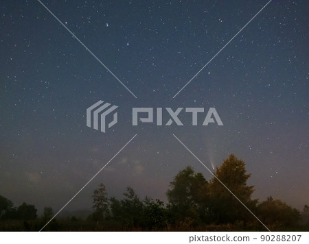 Comet Neowise C2020 F3 as it flies overhead in the summer sky over over meadow near countryside road, Lviv Region, Ukraine. 90288207