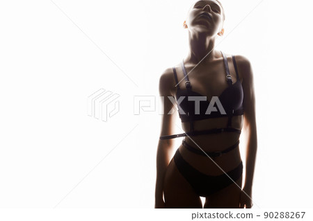 Beautiful woman in leather accessories and underwear. sexy girl in white lights Beautiful woman in leather accessories and underwear. sexy girl in white lights 90288267