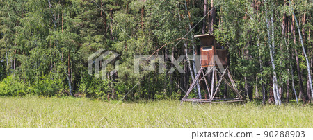 wooden hunting blind on the edge of the forest, near the meadow 90288903