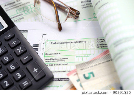 German income tax return form with european euro money bills and calculator lies on accountant table close up. The concept of taxpaying period in Germany 90291520
