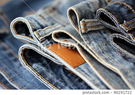 Many jeans in stack in wardrobe room. Row of pants denim jeans in closet. Concept of buy, sell, shopping and fashionable clothes Many jeans in stack in wardrobe room. Row of pants denim jeans in closet. Concept of buy, sell, shopping and fashionable clothes 90291722