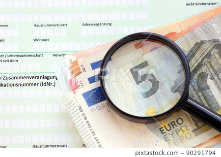 German income tax return form with magnifying glass and european euro money bills lies on accountant table close up. Taxpayers in Germany using euro currency to pay taxes German income tax return form with magnifying glass and european euro money bills lies on accountant table close up. Taxpayers in Germany using euro currency to pay taxes 90291794