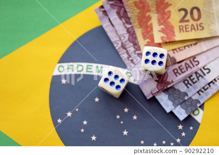 Dice cubes with brazilian money bills on flag of Brasil Republic. Concept of luck and gambling in Brasil Dice cubes with brazilian money bills on flag of Brasil Republic. Concept of luck and gambling in Brasil 90292210