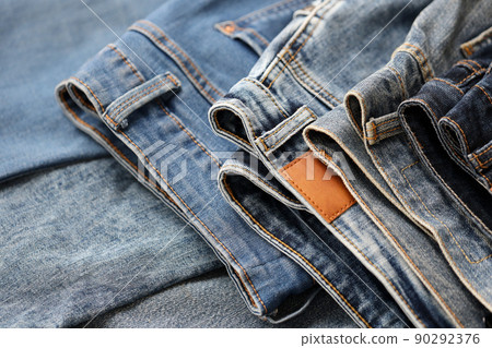 Many jeans in stack in wardrobe room. Row of pants denim jeans in closet. Concept of buy, sell, shopping and fashionable clothes Many jeans in stack in wardrobe room. Row of pants denim jeans in closet. Concept of buy, sell, shopping and fashionable clothes 90292376