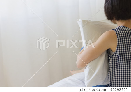 女人坐在床上，拿著枕頭 2 90292501