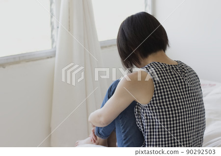 一個女人把膝蓋放在床上的背影 90292503