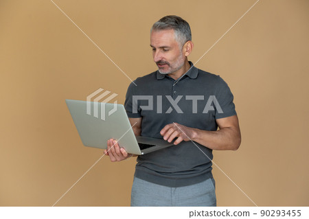 A mid aged gray-haired confident businessman with a laptop 90293455