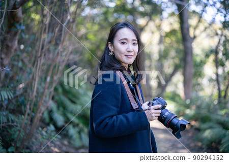 在陽光下的路上拍照的女孩 90294152