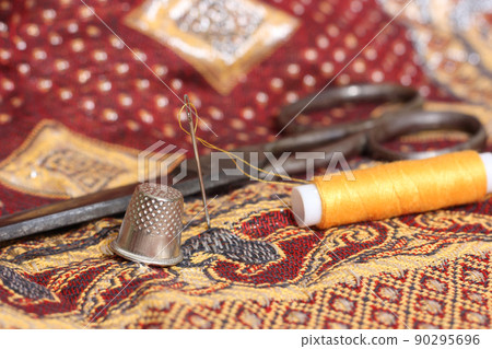 Golden Thread and Thimble on Vintage Fabric From The Middle East Golden Thread and Thimble on Vintage Fabric From The Middle East 90295696