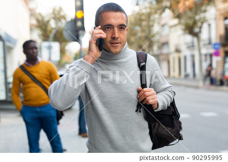 Caucasian man talking on phone outdoors Caucasian man talking on phone outdoors 90295995