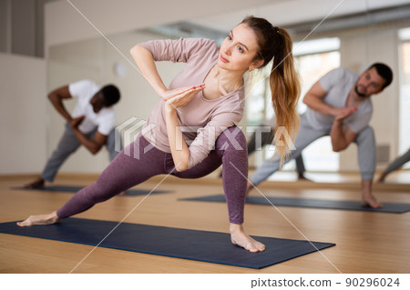 Woman doing yoga postures on group training Woman doing yoga postures on group training 90296024