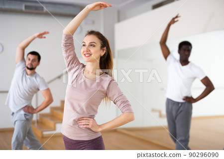 Woman practicing classic dance moves during group class 90296090