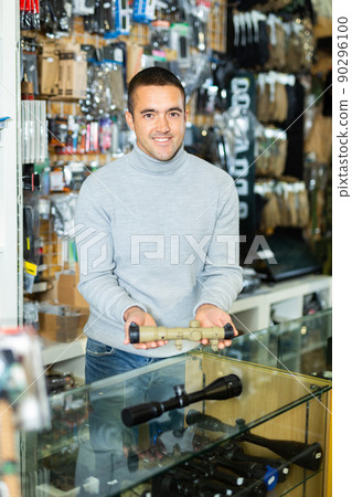 Seller man at counter in weapon shop 90296100