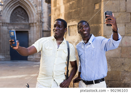 African-american tourists taking selfie on mobile phone at street 90296103