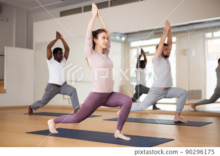 Woman standing in Ashta Chandrasana with hands in namaste over head Woman standing in Ashta Chandrasana with hands in namaste over head 90296175