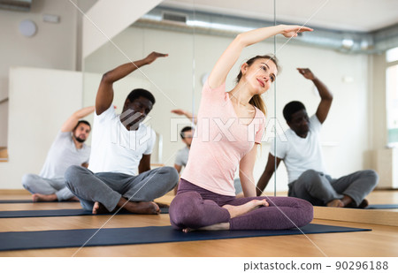 Woman sitting in lotus pose, group training 90296188