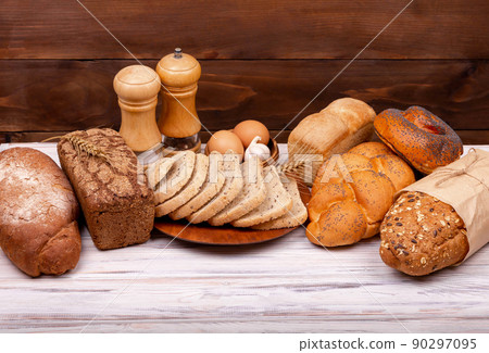 Assortment of tasty baked bread on dark and white background . 90297095