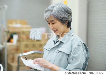 一名工人的高級女商人在倉庫盤點 一名工人的高級女商人在倉庫盤點 90298477