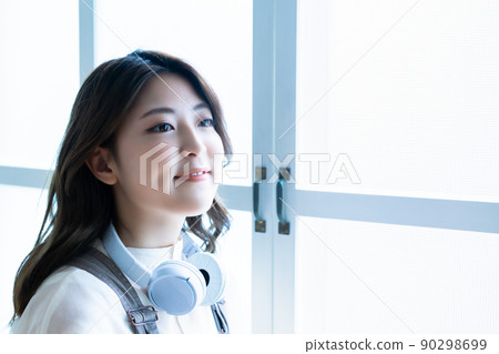 Young woman wearing headphones around her neck Young woman wearing headphones around her neck 90298699