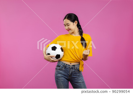 Asian Girl football fan over isolated pink background holding a soccer ball, sport concept Asian Girl football fan over isolated pink background holding a soccer ball, sport concept 90299054