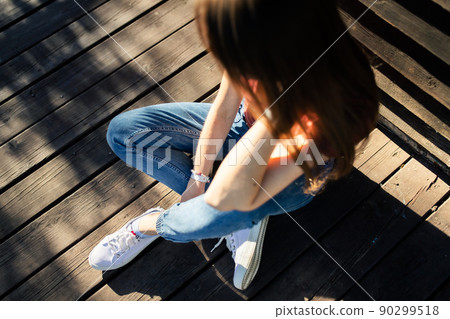 A woman sits on the terrace on a summer day and relaxing. Top view. 90299518