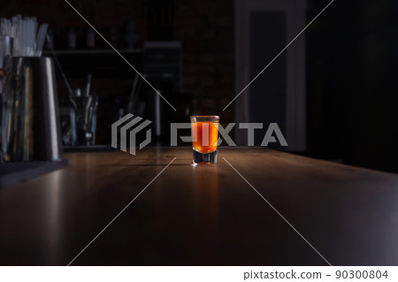 Drinking alone. Alcoholic shot at night bar.  90300804