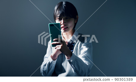 High school girls who are worried when they see their smartphones High school girls who are worried when they see their smartphones 90301389