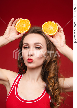 A beautiful woman in a red swimsuit with oranges A beautiful woman in a red swimsuit with oranges 90302613