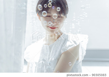 Young woman with soap bubbles and short hair Young woman with soap bubbles and short hair 90305083