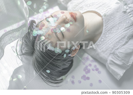 Young woman with sequins and short hair lying down Young woman with sequins and short hair lying down 90305309
