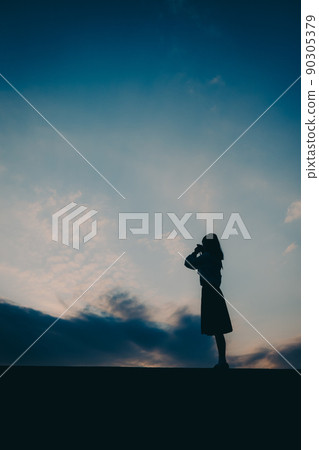 The silhouette of a high school girl in uniform and the beautiful sunset sky The silhouette of a high school girl in uniform and the beautiful sunset sky 90305379