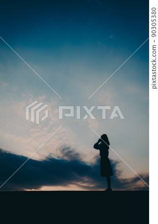 一個穿制服的高中女生的剪影和美麗的夕陽天空 一個穿制服的高中女生的剪影和美麗的夕陽天空 90305380