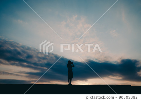 一個穿制服的高中女生的剪影和美麗的夕陽天空 一個穿制服的高中女生的剪影和美麗的夕陽天空 90305382