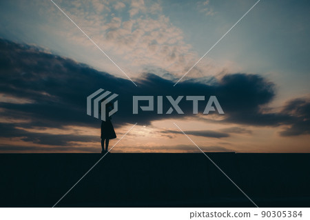 The silhouette of a high school girl in uniform and the beautiful sunset sky The silhouette of a high school girl in uniform and the beautiful sunset sky 90305384