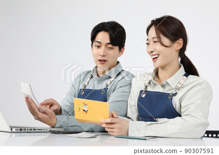 Asian Korean young man and woman startup concept_ rejoicing while looking at bankbooks and calculators Asian Korean young man and woman startup concept_ rejoicing while looking at bankbooks and calculators 90307591