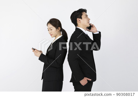 Asian Korean young generations woman and man job interview concept_ Back to back looking at smartphone Asian Korean young generations woman and man job interview concept_ Back to back looking at smartphone 90308017