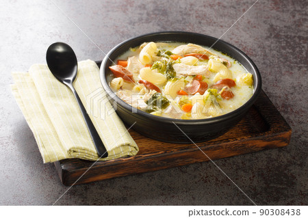 Filipino chicken soup with elbow pasta, vegetables, sausages close-up in a bowl. Horizontal Filipino chicken soup with elbow pasta, vegetables, sausages close-up in a bowl. Horizontal 90308438