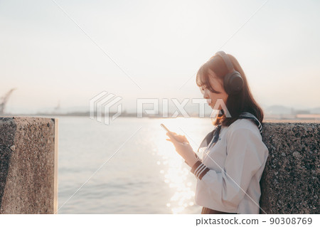 Schoolgirl in uniform and beautiful sunset sky 90308769