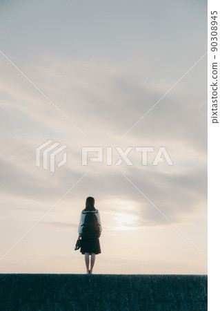 Schoolgirl in uniform and beautiful sunset sky 90308945