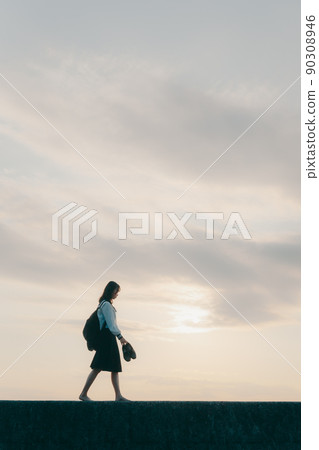 Schoolgirl in uniform and beautiful sunset sky Schoolgirl in uniform and beautiful sunset sky 90308946