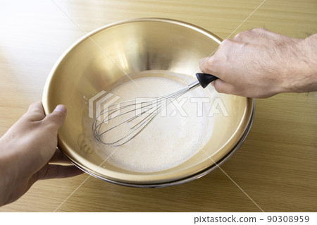 Image of a man whisk cream with a whisk Image of a man whisk cream with a whisk 90308959
