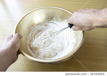 Image of a man whisk cream with a whisk 90308960
